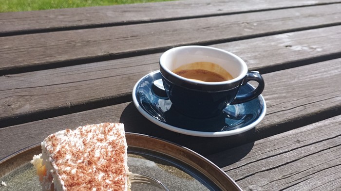 Kaffee und Kuchen auf Holztisch im Park
