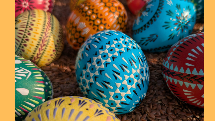 Bunt bemalte Ostereier, arrangiert auf einem Bett aus braunem Papierstreu.