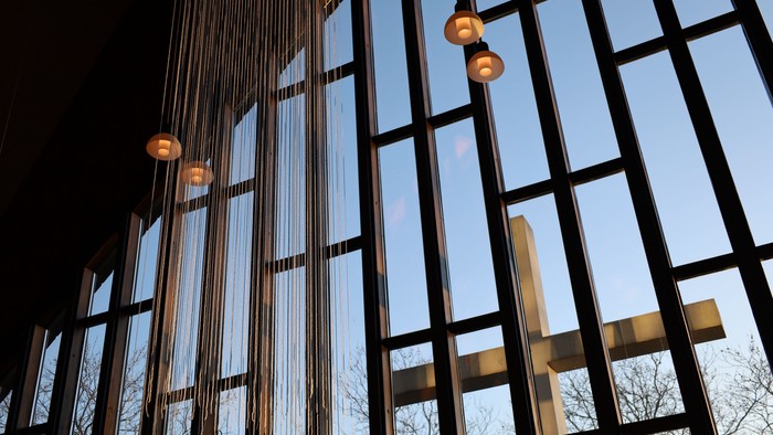 Moderne bygning med store glasvinduer og hængende lamper.