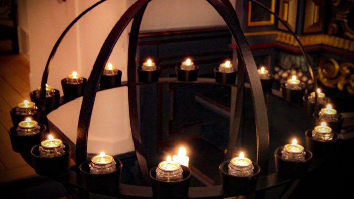 En kandelaber med flere lysede lygter i en kirke.