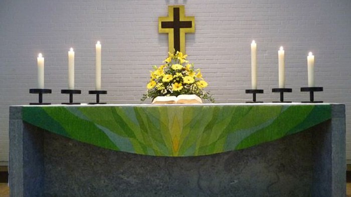 Altar mit Kerzen und Kreuz in Kirche