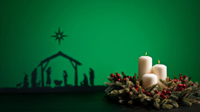 Nativité avec deux bougies et couronne de Noël sur fond vert