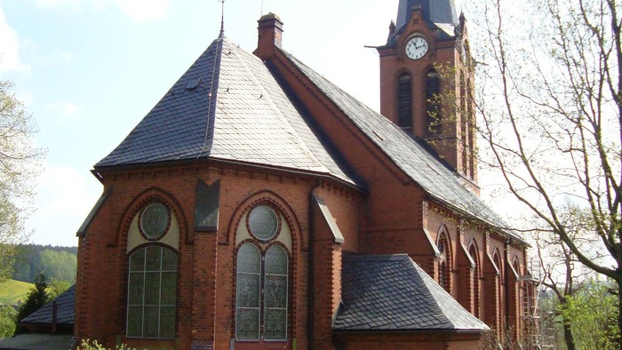 Kirchengrundstück mit Kirche, Uhrturm und Grabsteinen