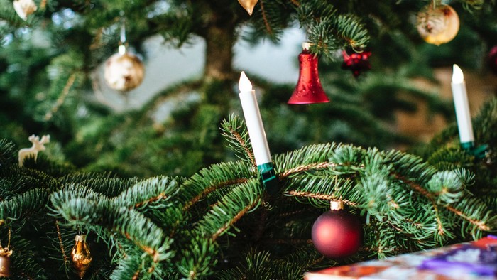 Ein Weihnachtsbaum mit roten Kugeln und Kerzen.