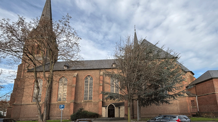 Große Backsteinkirche mit hohen Türmen und Bogenfenstern.