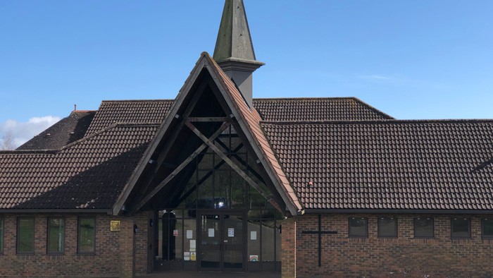 Church building with tall steeple and brick exterior