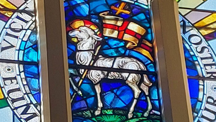 Buntes Kirchenfenster mit Lamm und Kreuz