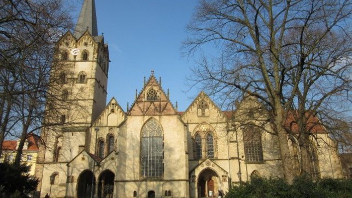 Gothische Kirche mit hohem Turm und spitzen Fenstern vor klarem Himmel