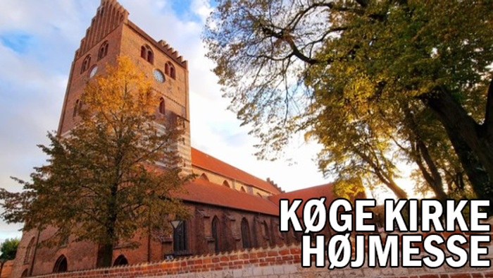 Køge Kirke med højt tårn og træer foran