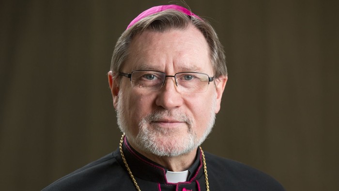 Ein Mann in bischöflicher Kleidung mit goldenem Kreuz