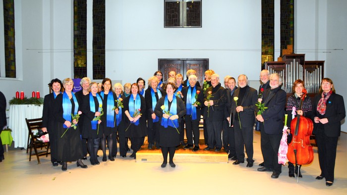 Ein Chor und Orchester posieren in einer Kirche