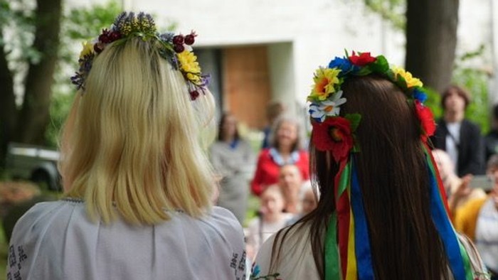 Zwei Frauen mit Blumenkränzen bei einem traditionellen Fest im Freien