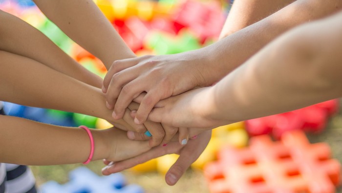 Børnehænder der holder fast i hinanden