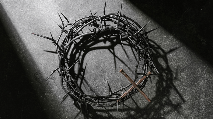 En skyggefuld gengivelse af en tornekrone oplyst af en enkelt lyskilde.