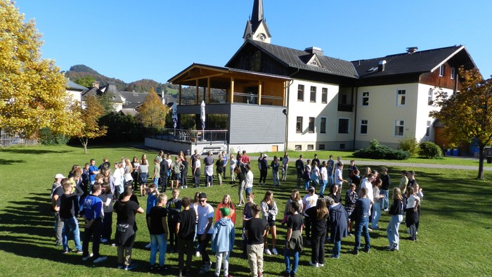Große Gruppe von Menschen vor einem Gebäude mit Kirche im Hintergrund