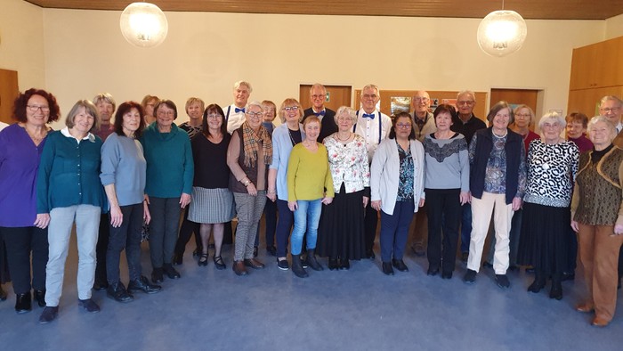 Gruppe von Personen, die drinnen für ein Foto posiert