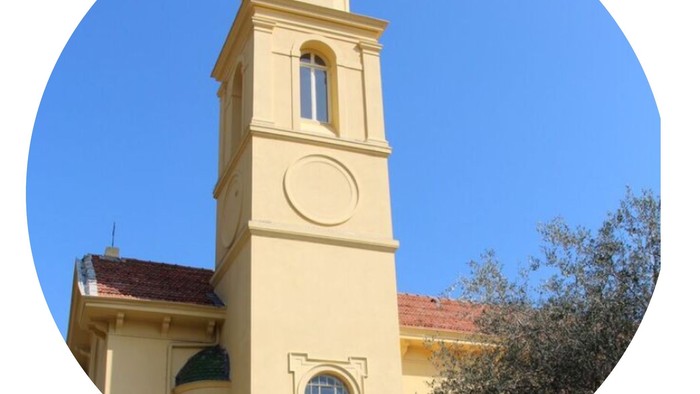 Tårn på gul bygning med klokke og vinduesåbning