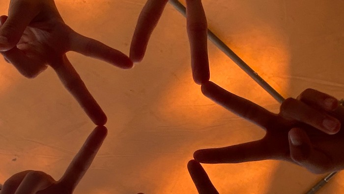 Mehrere Hände bilden ein Muster auf einer Holzoberfläche