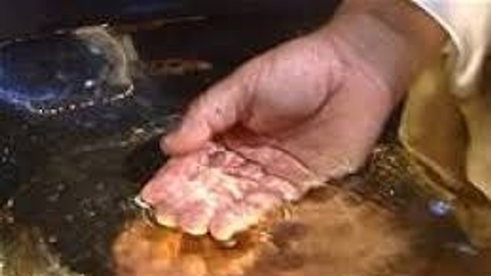 Hånd holdes over kælder med vand.