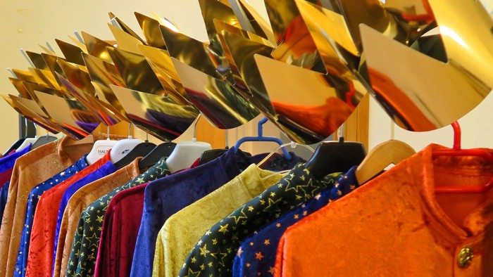 Bunte Kleider auf Bügeln mit goldenen Aufhängern
