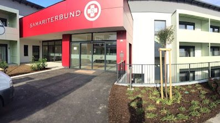 Das Bild zeigt ein modernes Gebäude mit einem roten und weißen Farbschema, das als 