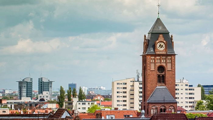 Ein Ziegelbau mit Uhrturm in einer Stadtlandschaft