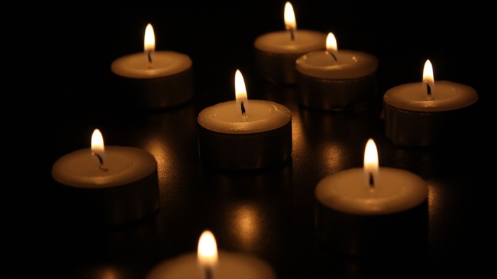 Several lit candles in dark background.