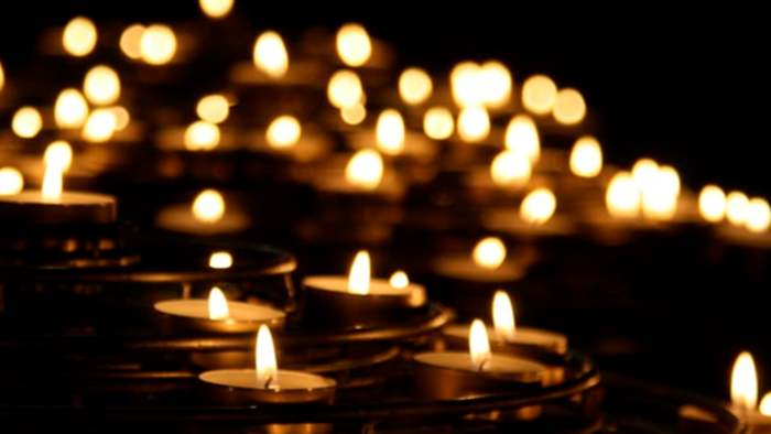 Numerous lit candles arranged in rows, creating a warm and serene atmosphere.