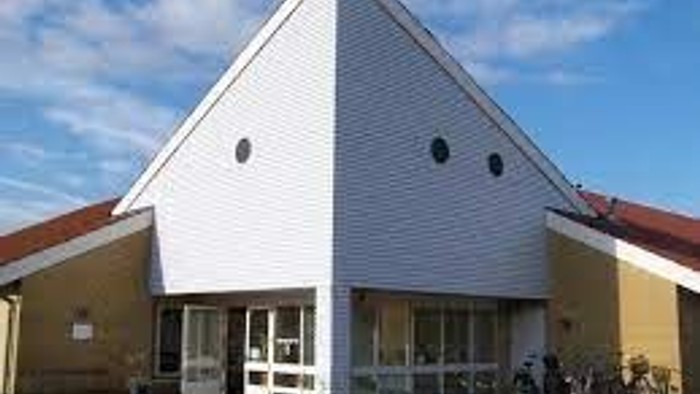 Et hvidt hus med tre cykler ved indgangen