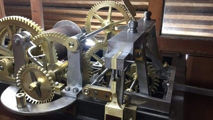 Komplekst messing- og metalurværk med sammenkoblede tandhjul og mekaniske forbindelser.