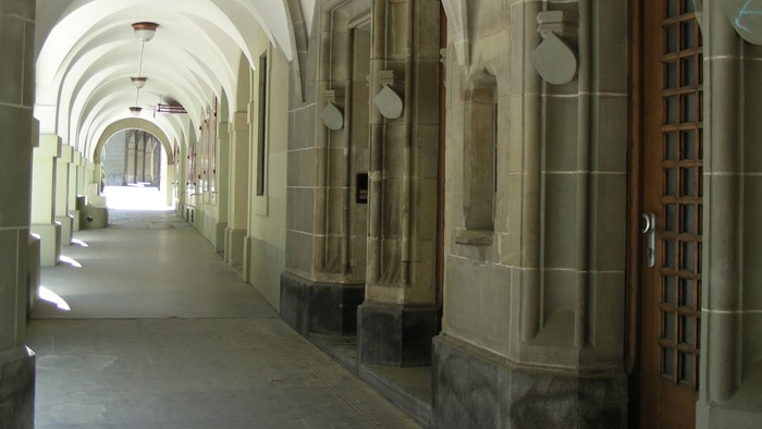 Steinerner Flur mit gewölbten Decken und Holztür