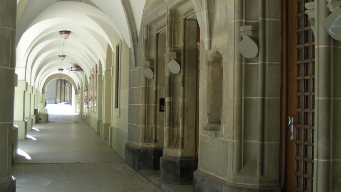 Steinerner Flur mit gewölbten Decken und Holztür