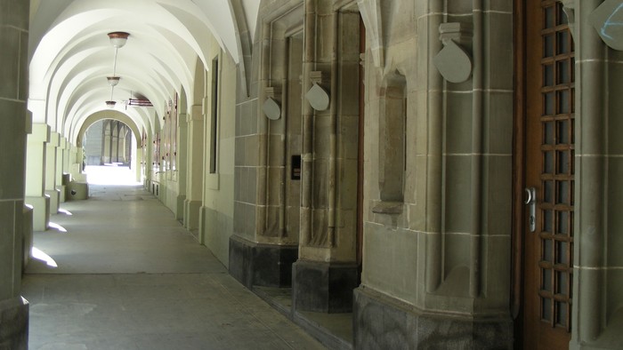 Steinerner Flur mit gewölbten Decken und Holztür