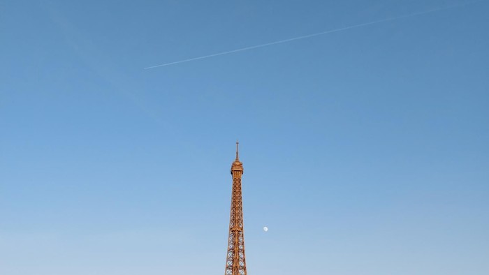 Eiffelturm bei Dämmerung beleuchtet mit Stadtpanorama im Hintergrund