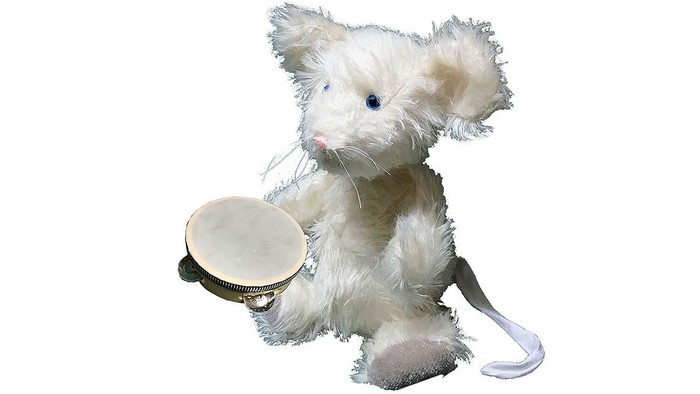 Die Kirchenmaus Gerti sitzt auf dem Boden und hält eine Handtrommel.