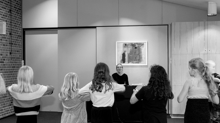 En gruppe børn danser og har sjov i et rum med murals.