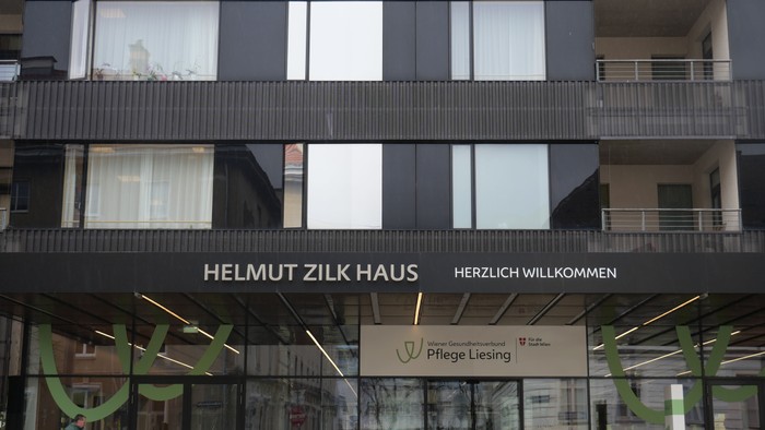 Das Gebäude Helmut Zilk Haus mit grünen Akzenten und Schildern.