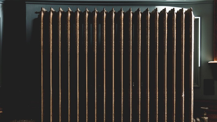 Elegante schwarze Samtvorhänge mit Holzstangen, die einen klassischen Innenraum einrahmen.