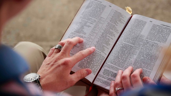 Eine Person liest eine Bibel im Freien.