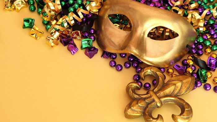 Guld mask og mardi gras-perler på gul baggrund