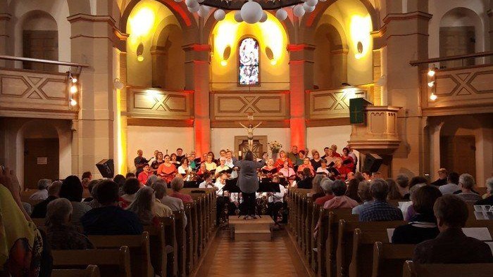 Kirchliche Zeremonie mit vielen Teilnehmern und großer Kronleuchter