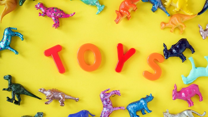 Colorful toy dinosaurs and letters spelling 