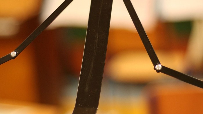 Nahaufnahme eines schwarzen Metall-Schirmgestells mit unscharfem Hintergrund.