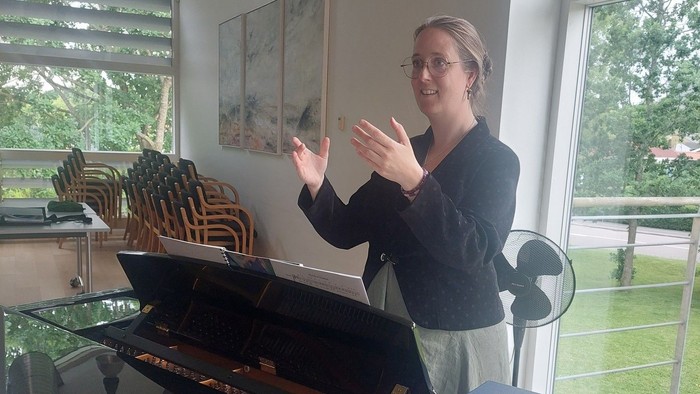 Kvinde ved piano i hhv. sal