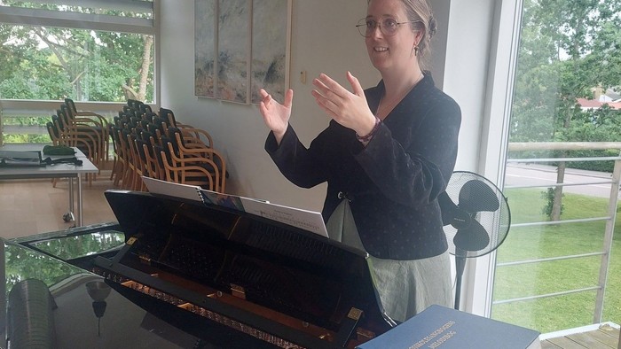 Kvinde ved piano i hhv. sal