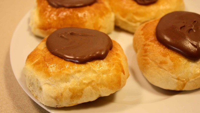 En rundt og hvidt brød med chokoladecreme på en pinde.