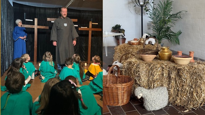 Børn i middelalderkostumer lytter til en fortæller, mens en krybbescene med høtema er udstillet i nærheden.