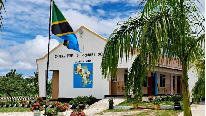 Das Bild zeigt eine Schule mit jamaikanischer Flagge und Palmen.
