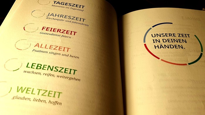 Buch aufgeschlagen auf einer Seite mit deutschem Text und buntem Design