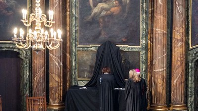 In prunkvollem Raum mit Gemälde und Kronleuchter.